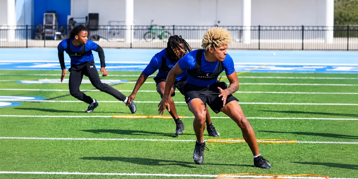 Athletes run an agility drill on a marked field.
