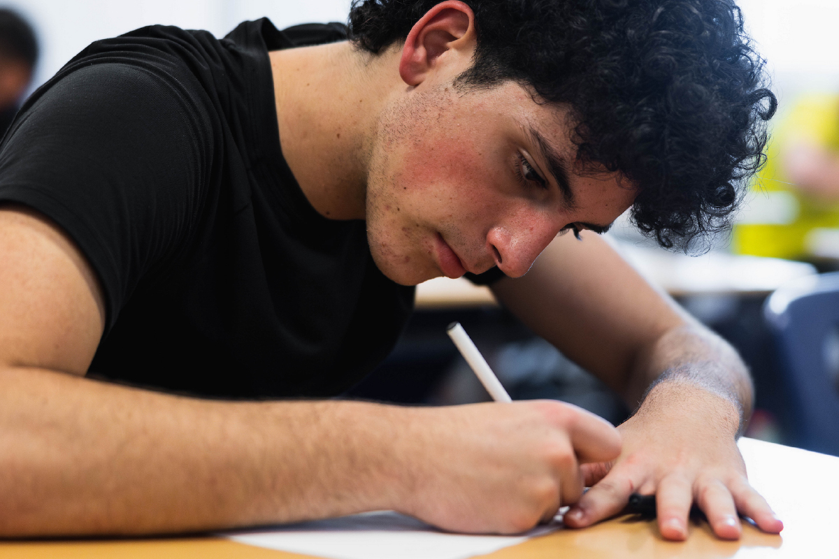 Male student taking notes.