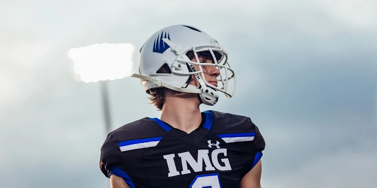 A helmeted football player looks across the field.