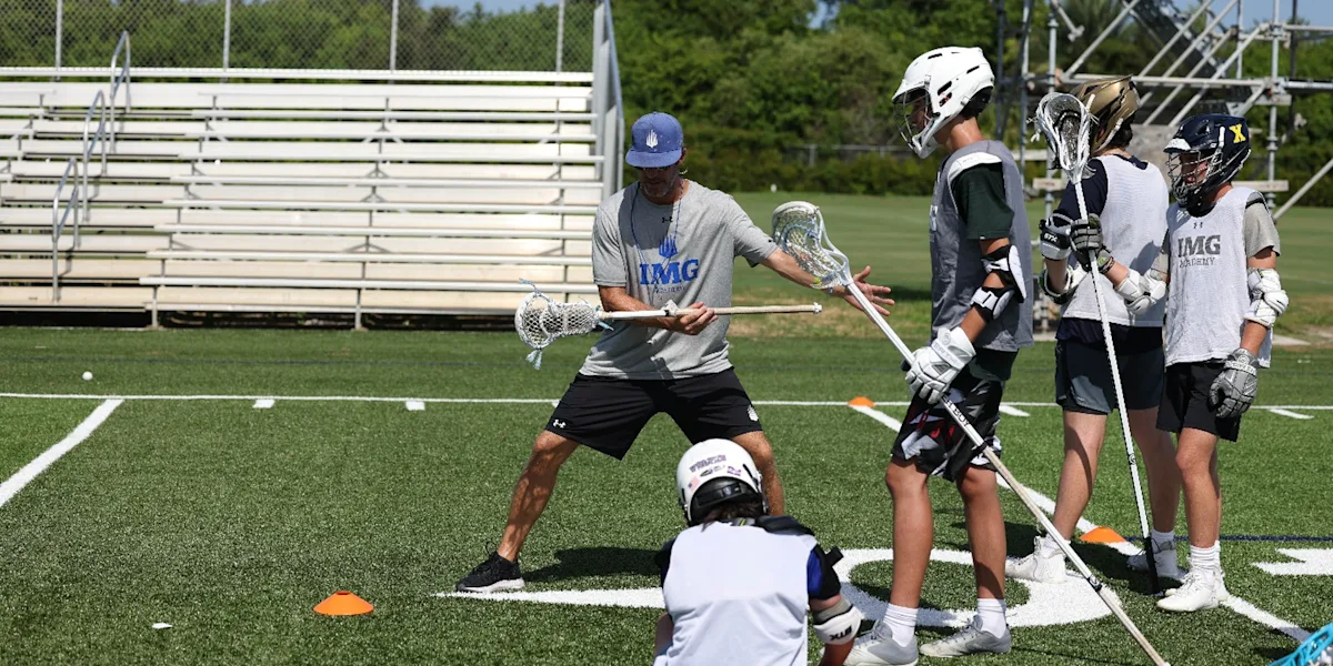 Lacrosse coach demonstrates stick skills to student-athletes during training at IMG Academy.