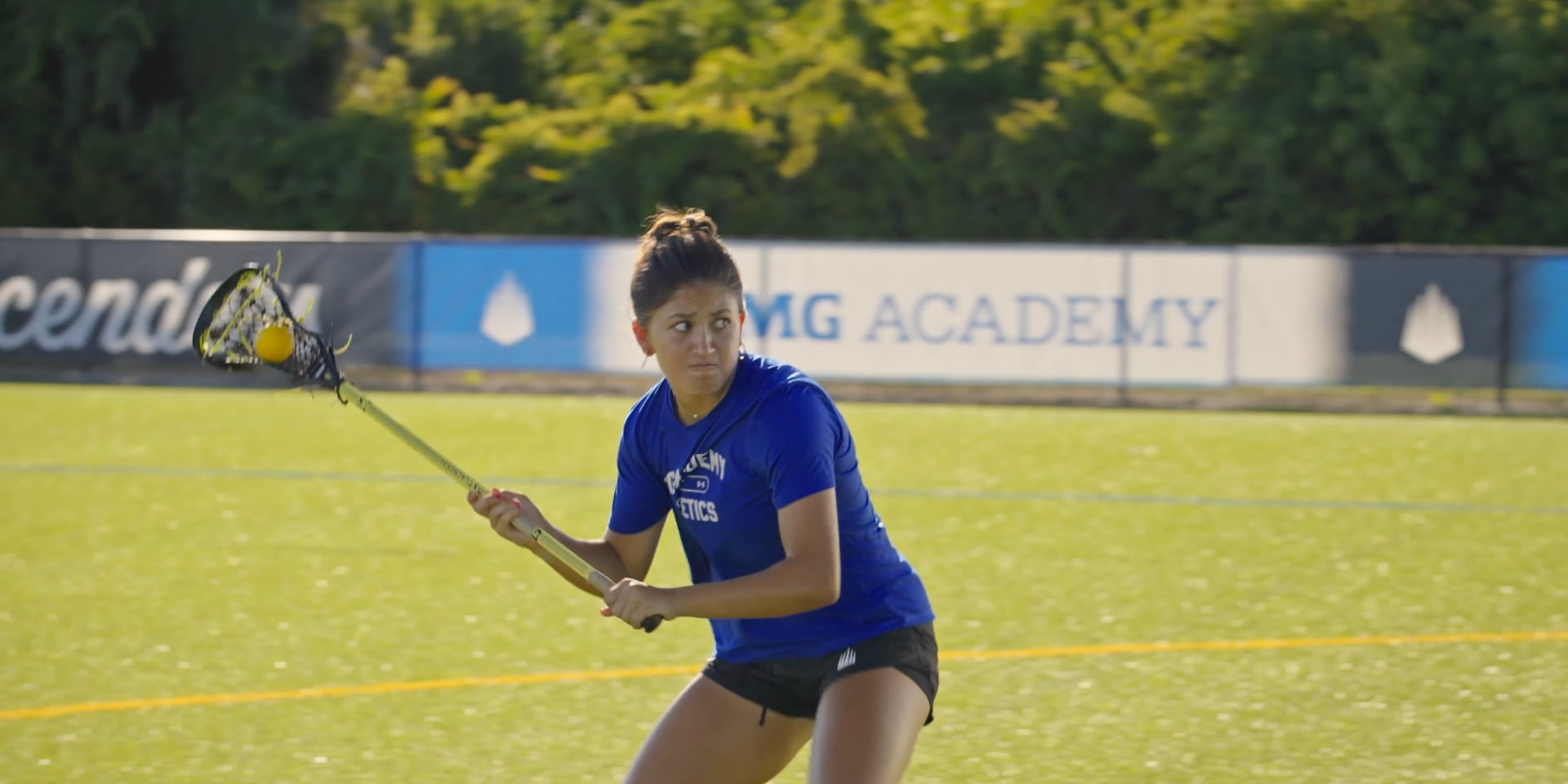 A lacrosse player holds her stick ready for a shot on the field.