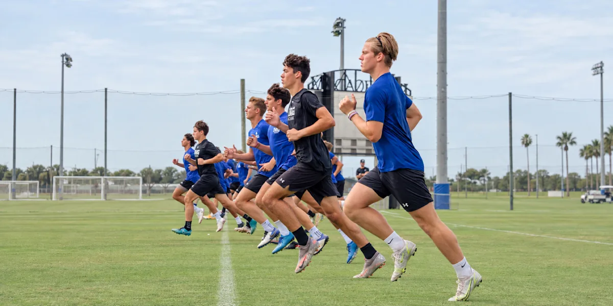 Athletes run together during an outdoor speed drill.