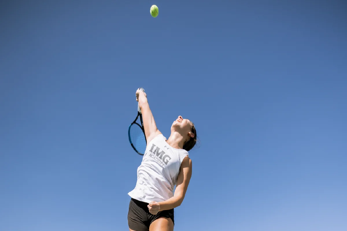 IMG Academy student-athlete serves a tennis ball