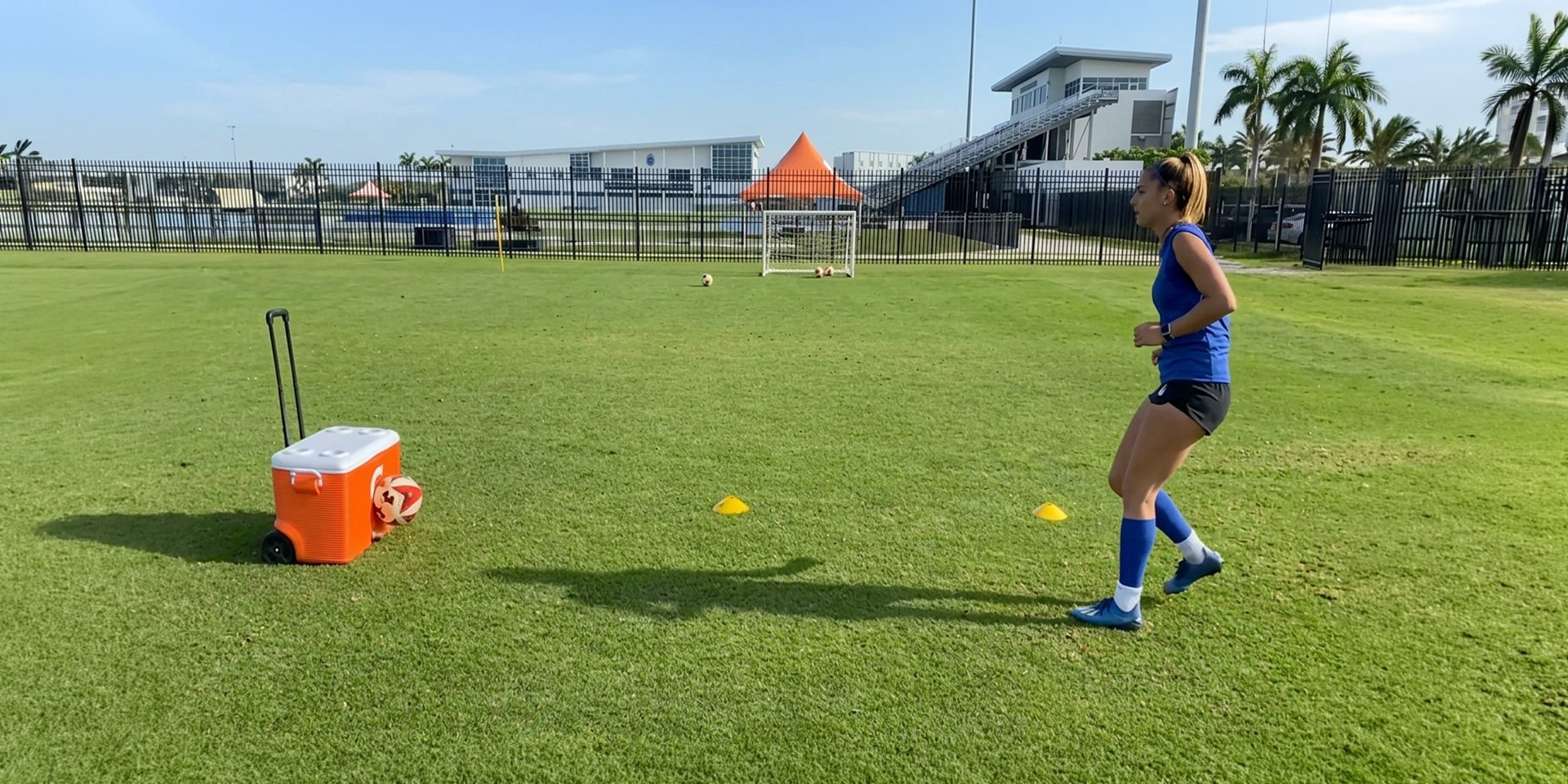 A soccer player practices finishing beside small targets on the field.