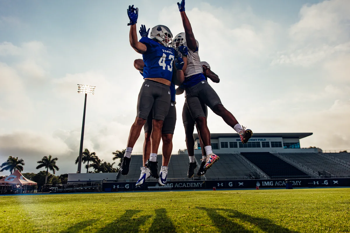Three IMG Academy football players celebrate a touchdown.