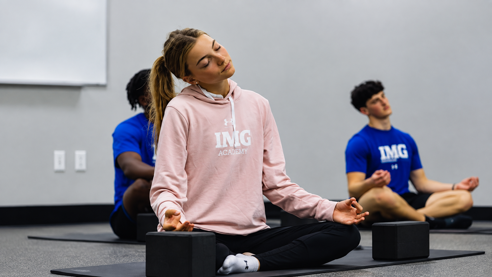 IMG Academy students participate in a guided meditation and recovery session indoors, supporting mental wellness, focus, and athletic performance.