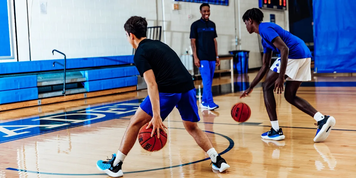 Student-athletes practice basketball dribbling drills with a coach at IMG Academy.