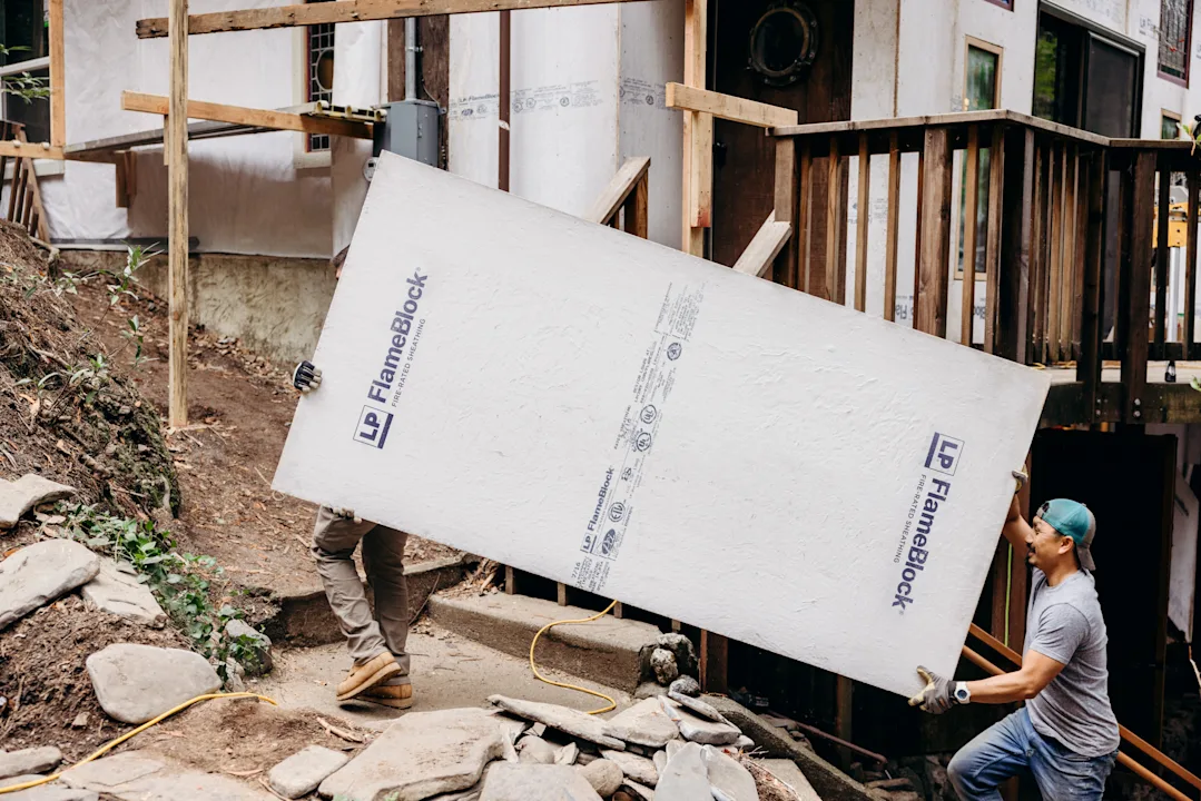Image of builders holding a panel of FlameBlock