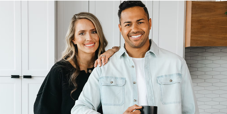 Brooke leaning on Brice, who is holding a coffee cup, smiling at the camera