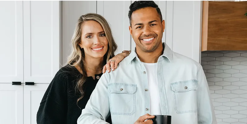 Brooke leaning on Brice, who is holding a coffee cup, smiling at the camera
