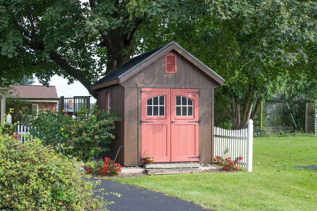 shed with brown vertical siding and a red door