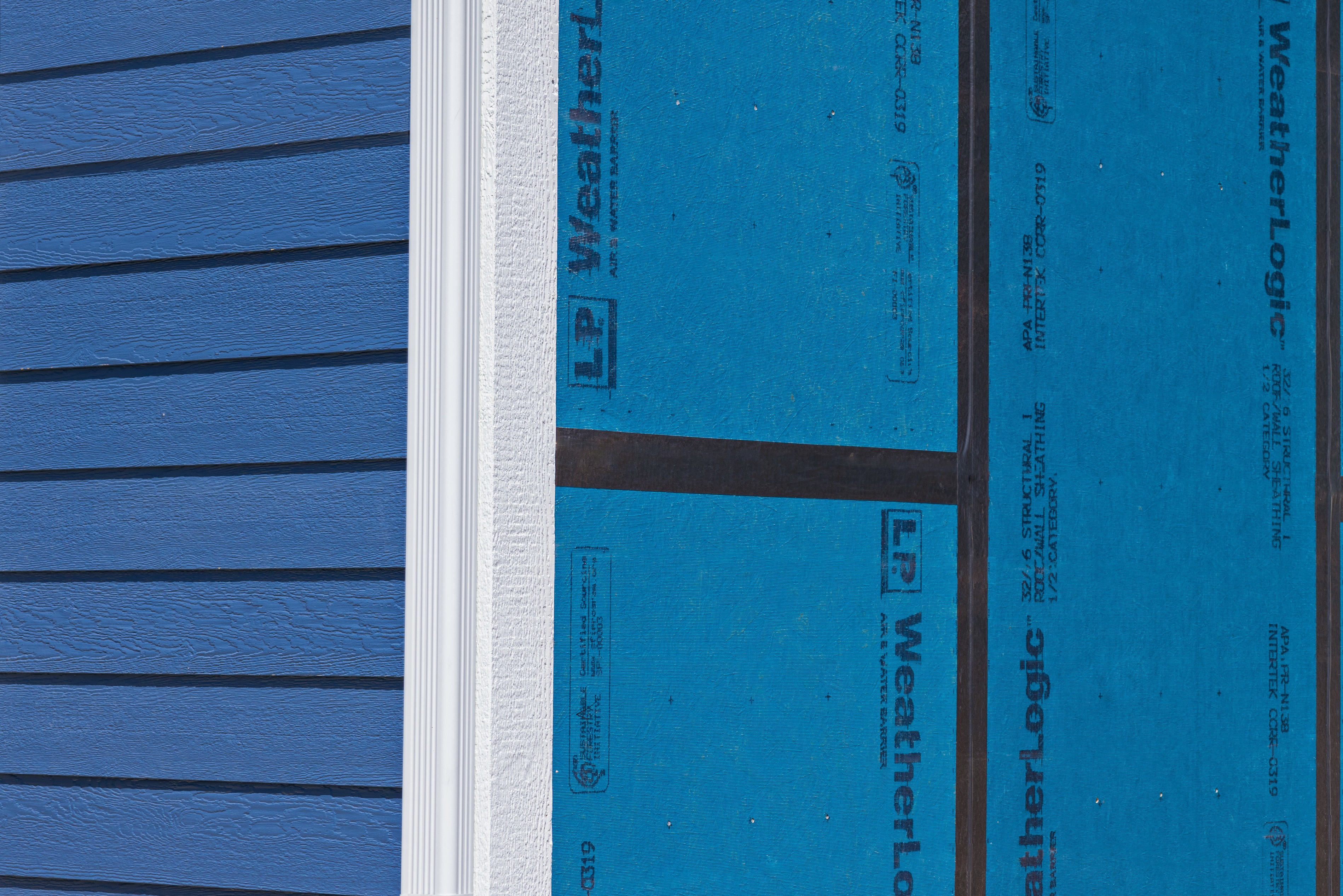 close up of house with blue siding no window
