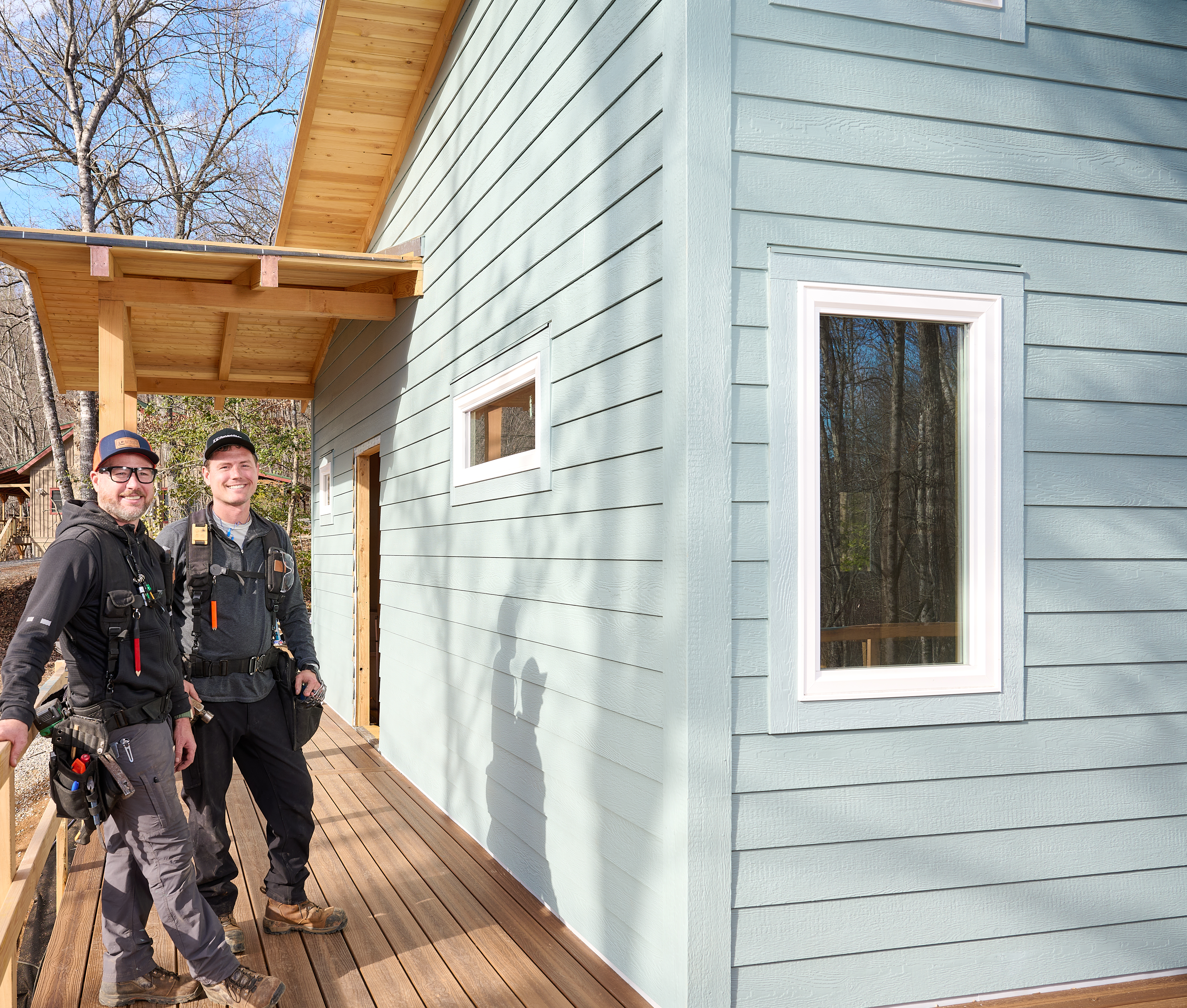 Image of two contractors standing next to a home