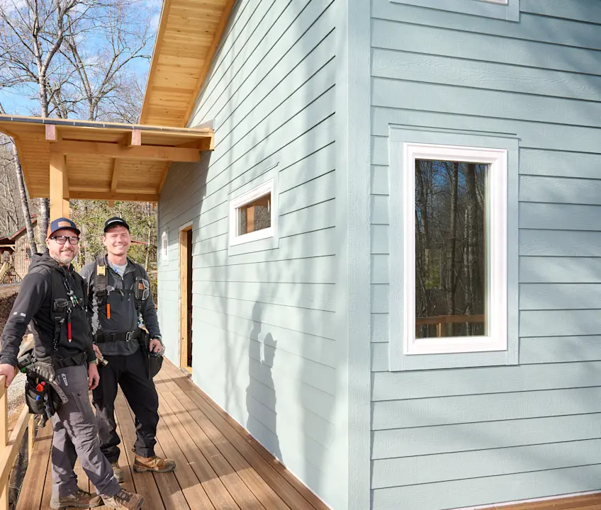 Image of two contractors standing next to a home