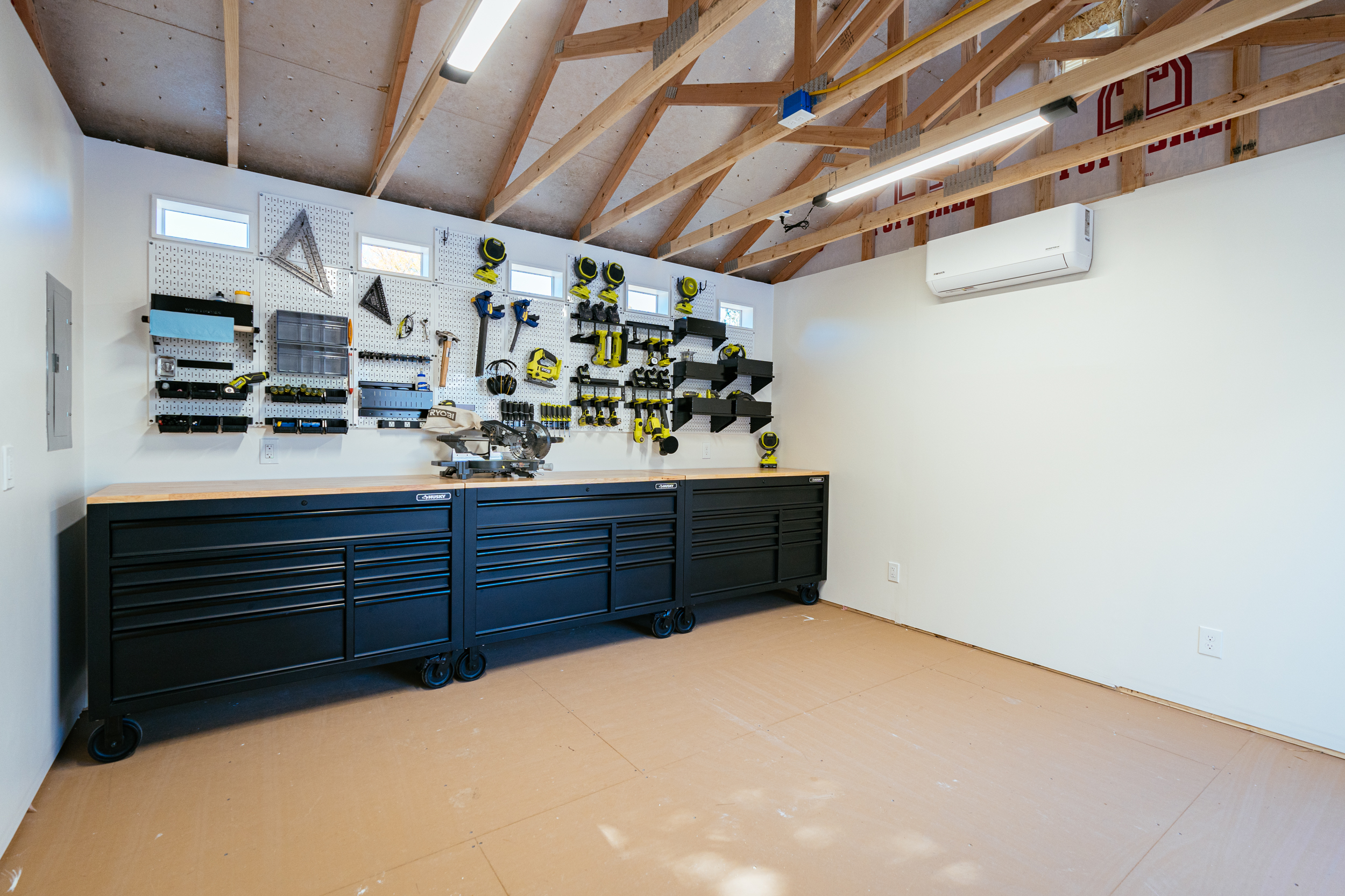 shed workshop with tool cabinets and tools hanigng from a pegboard