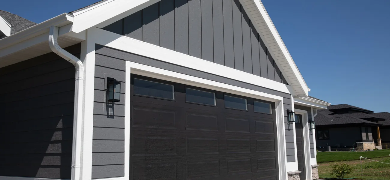garage with gray lap and vertical siding