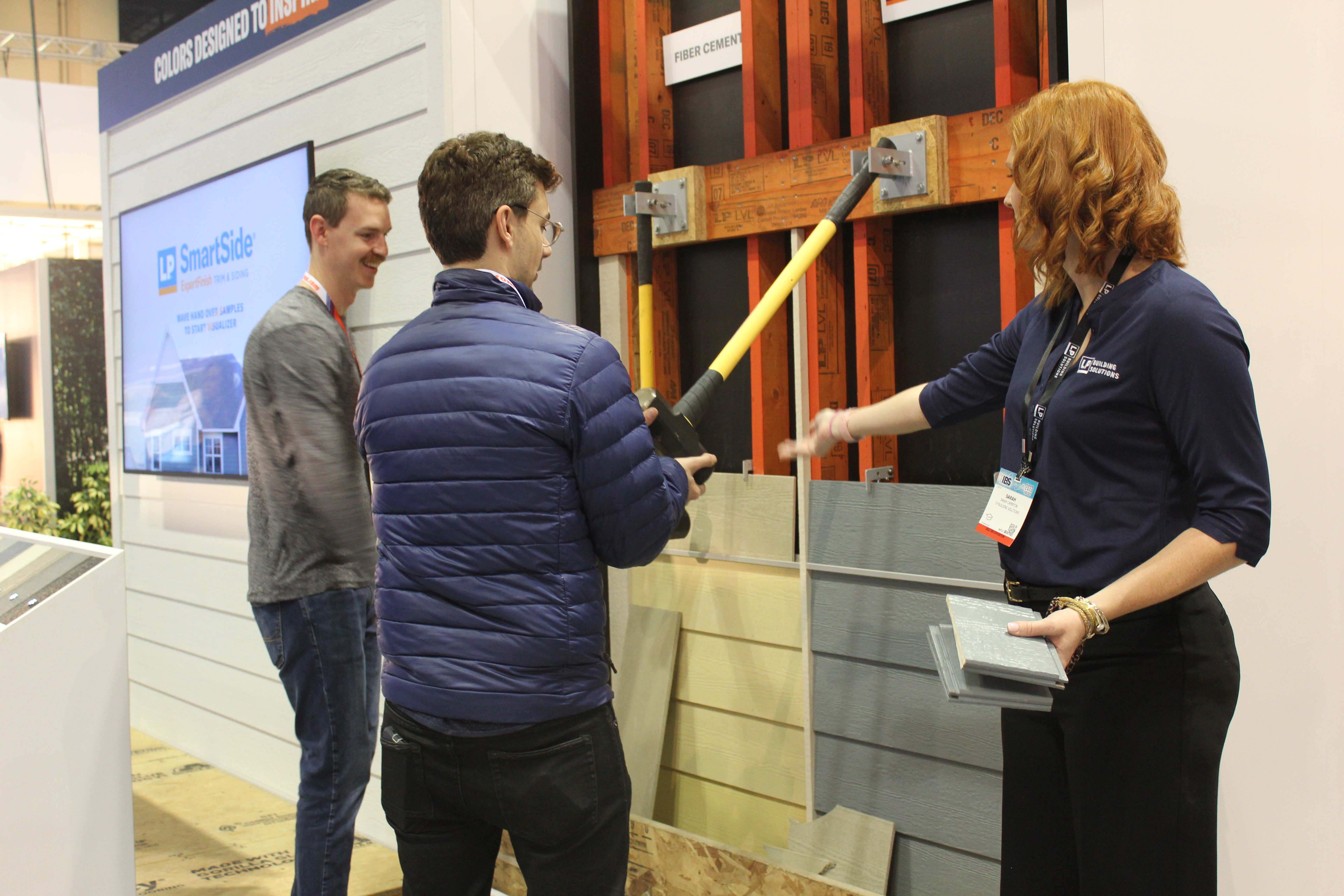 people at ibs testing smartside with a hammer drop