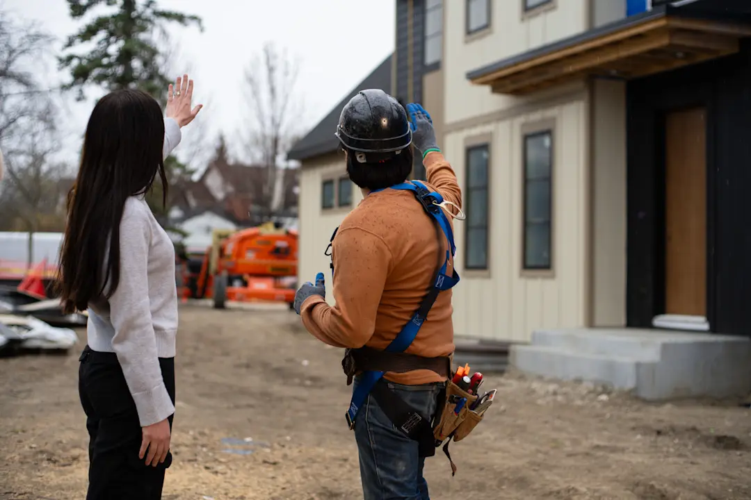 a homeowner speaking with their homebuilder on a construction site