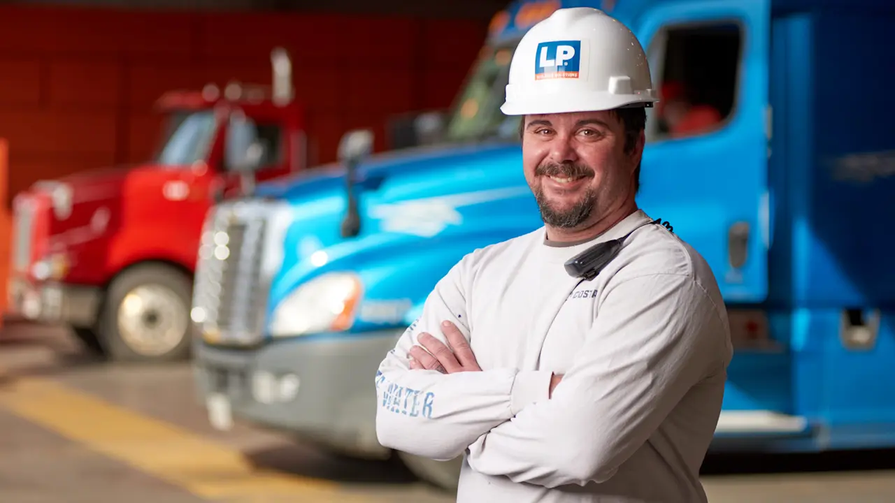 man in white lp hard hat in front of trucks