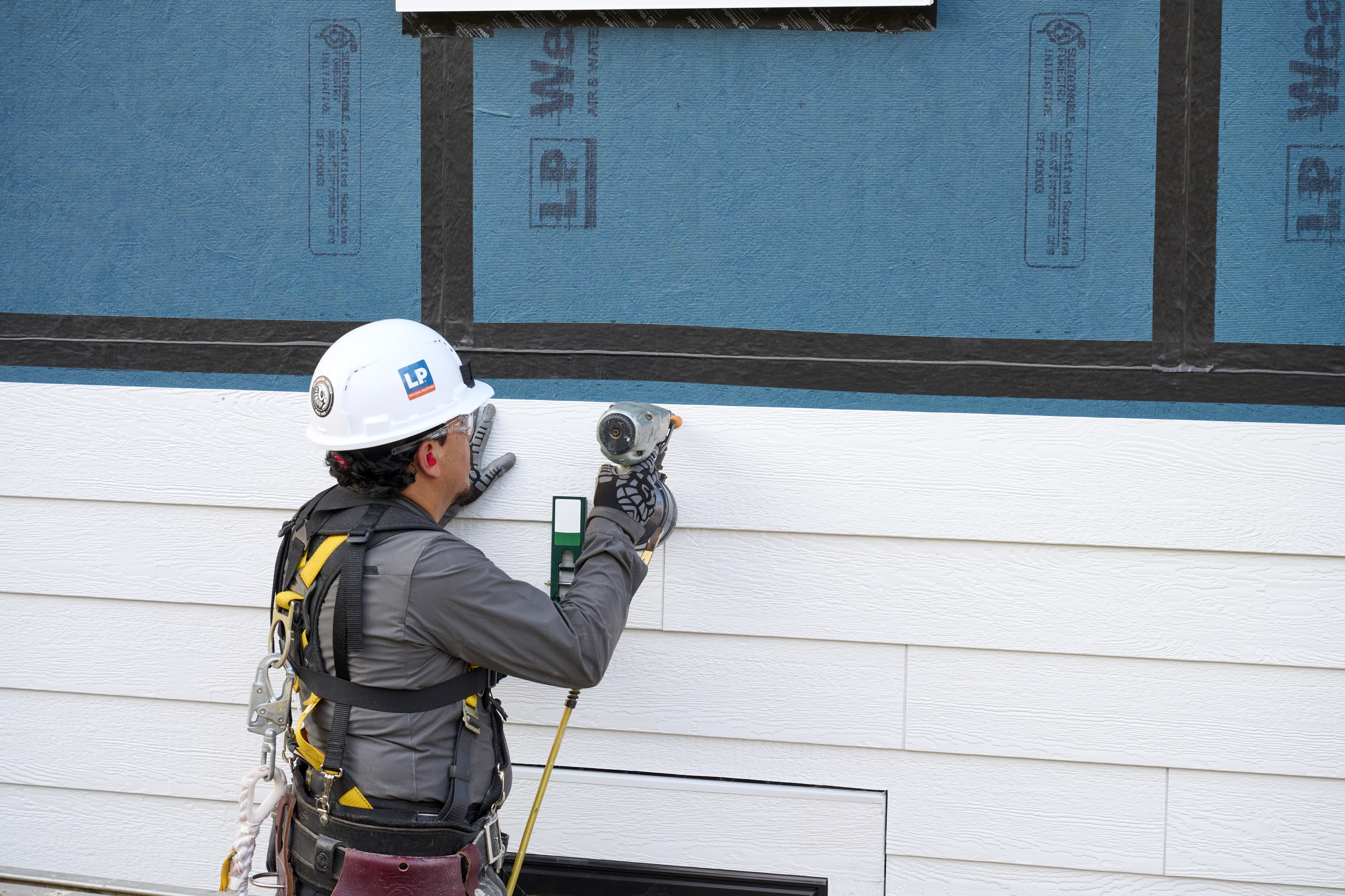 Image of builder installing siding on top of WL