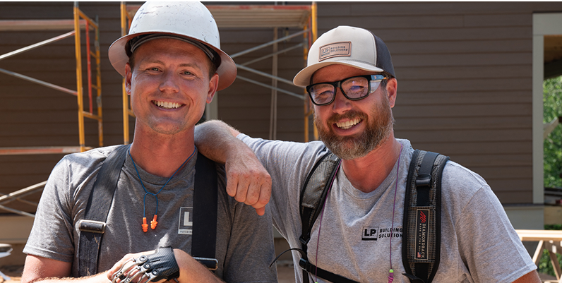 The Perkins brothers leaning on each other and looking at the camera, smiling
