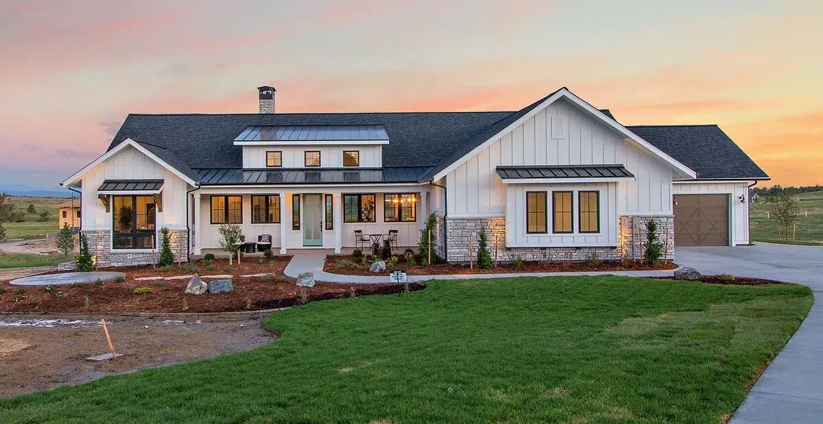 a ranch style home with white siding and stone