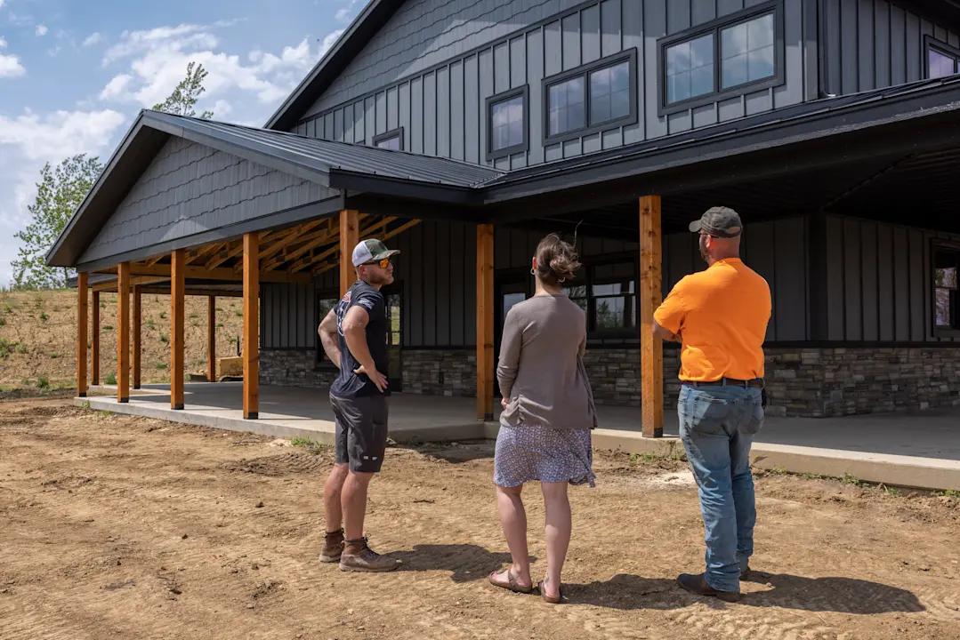 a contractor speaking with homeowners outside of their houe
