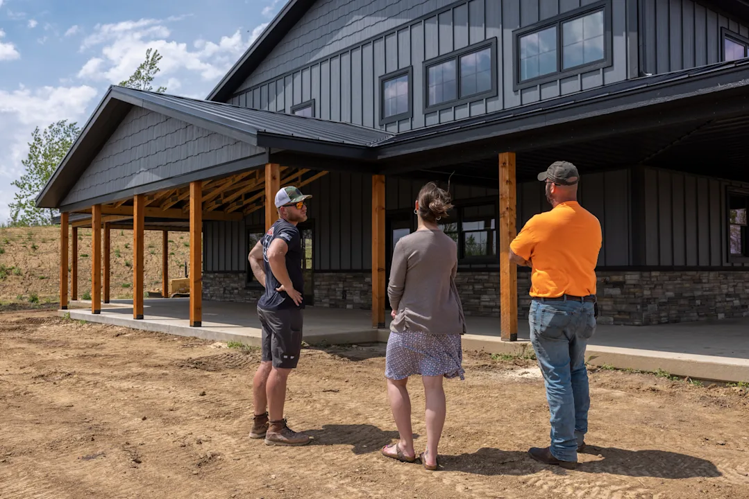 a contractor speaking with homeowners outside of their houe