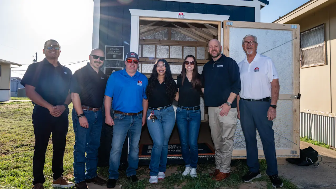 Image of members in front of the shed