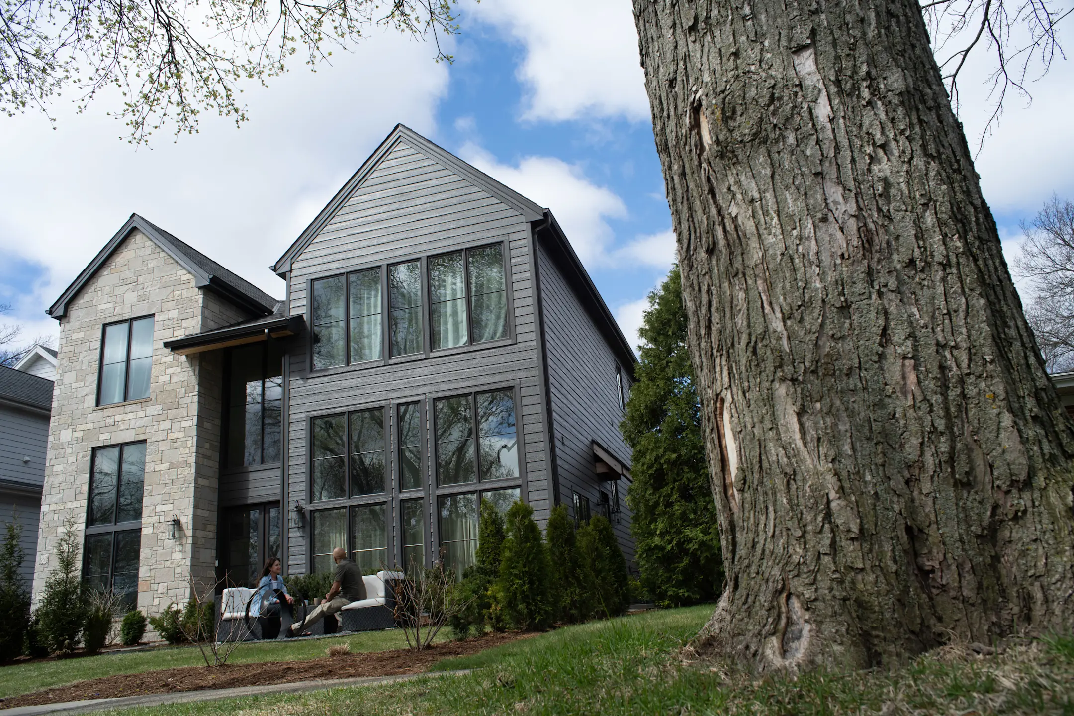 exterior of home with black siding and stone wall