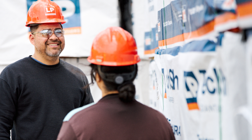 workers wearing orange helmets talking