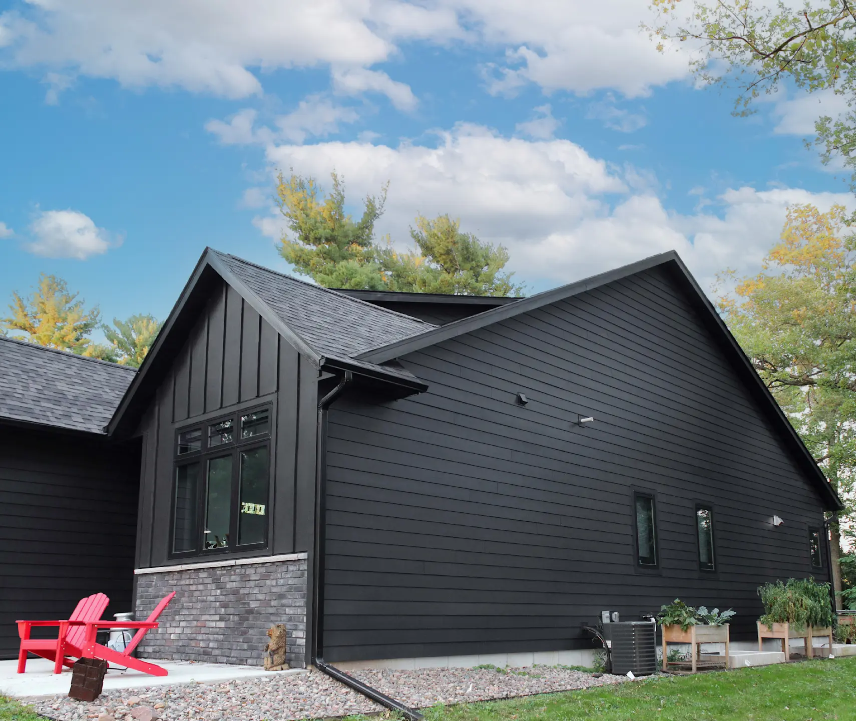 side angle of a house with black board and batten and lap siding
