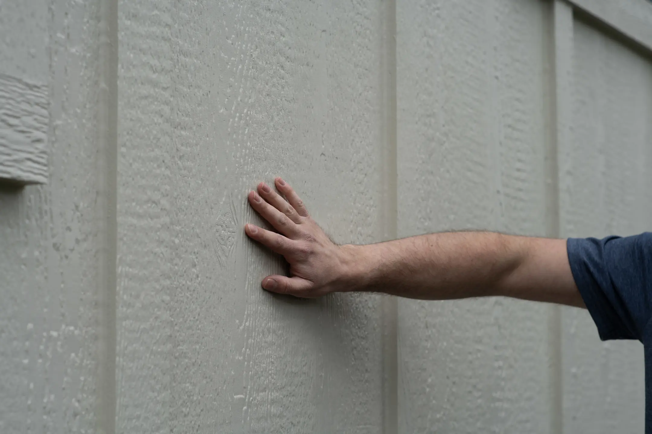 hand on wall with lp lap siding