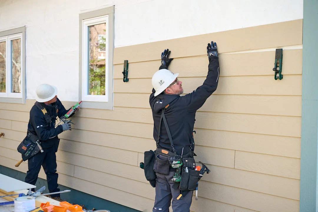 Builders installing LP SmartSide siding on a home.