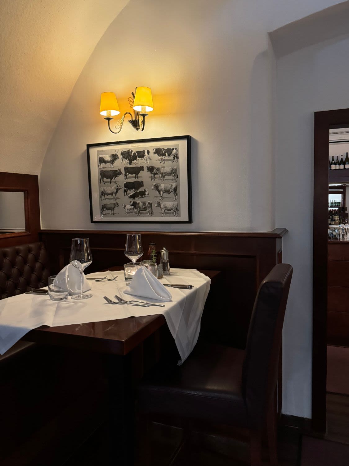Wnętrze restauracji Steak Boutique w Grazu. Na stoliku leży przygotowana zastawa - sztućce, serwetki, kieliszki.