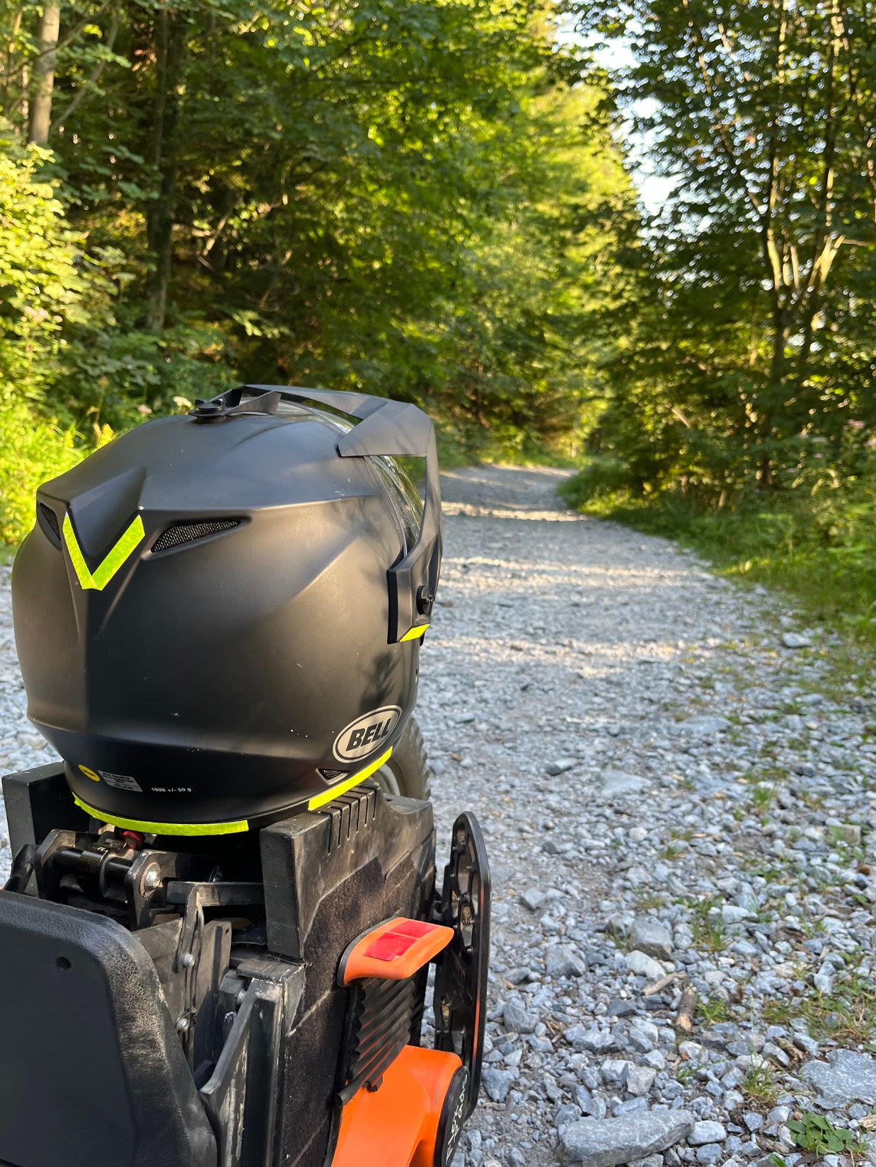Na leśnej drodze, która prowadzi na górę Schöckl stoi koło elektryczne a nim postawiony jest kask motocyklowy.