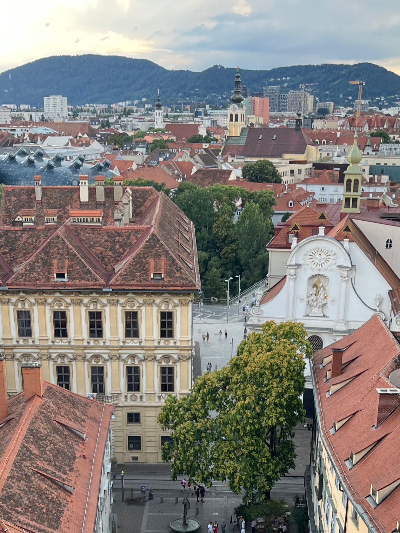 Zbliżenie na zabytkowe dachy w Grazu. Wśród zabudowy Kunsthaus Graz - galeria sztuki współczesnej. 