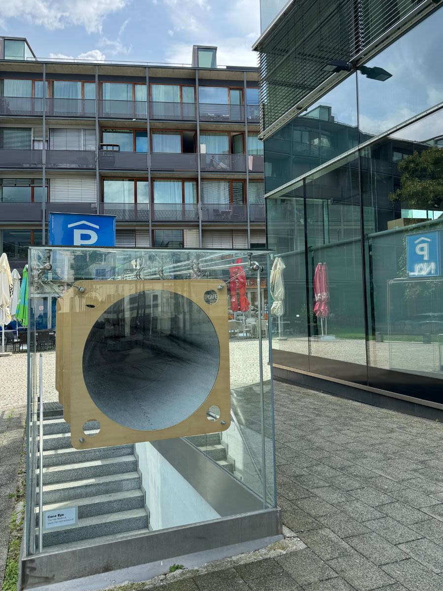 Wejście do parkingu w centrum Innsbrucka przy ulicy Kaiserjägerstraße 1. Przy wejściu znajdują się nowoczesne szklane budynki.