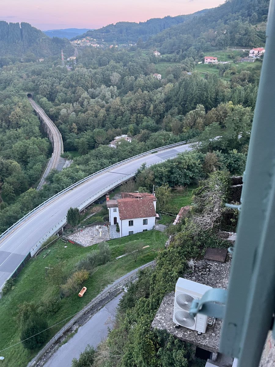 Widok z twierdzy La Rocca di Camporgiano w Toskanii. W dole widać domy oraz drogę i tunele.
