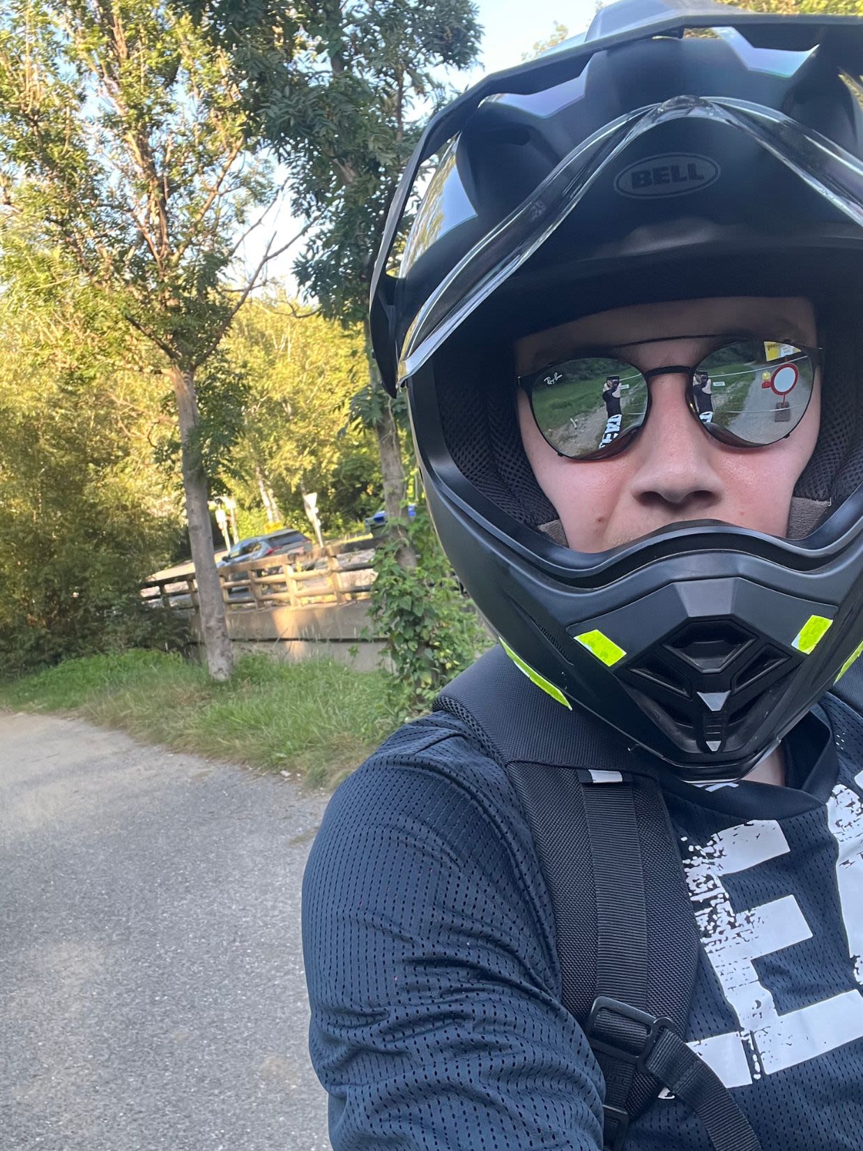Mężczyzna w dużym kasku i okularach jedzie monocyklem po drodze w okolicach Grazu latem.