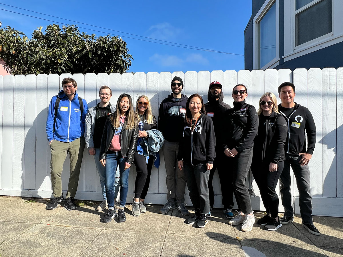 Group of people standing in front of a white fence