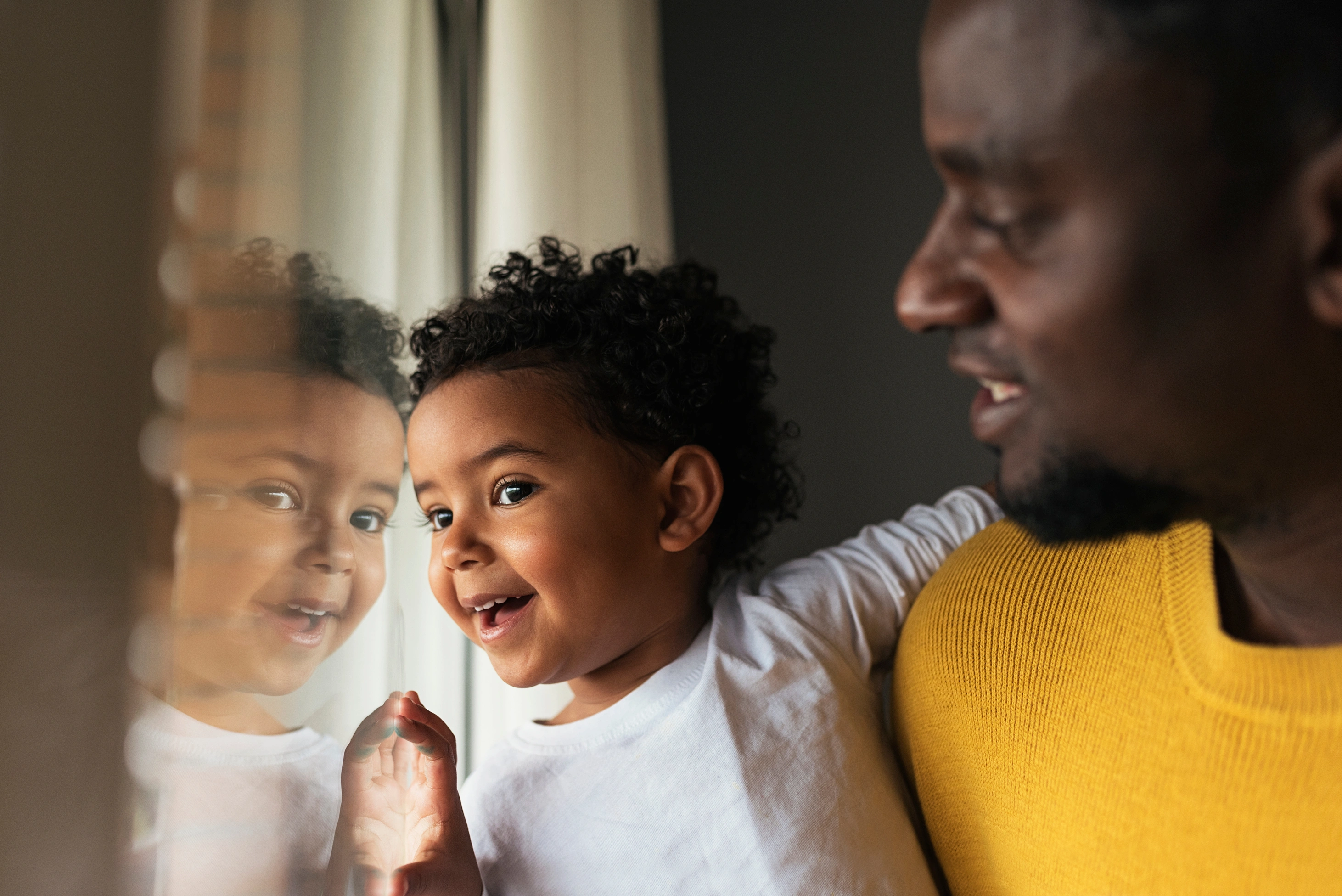 Ein glücklicher Vater und seine Tochter haben zu Hause gemeinsam Spaß. Eine Familie mit unterschiedlicher Herkunft.