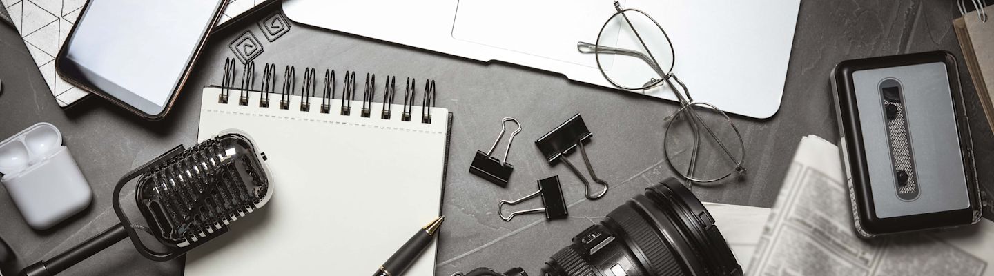 Flat lay composition with equipment for journalist on grey table