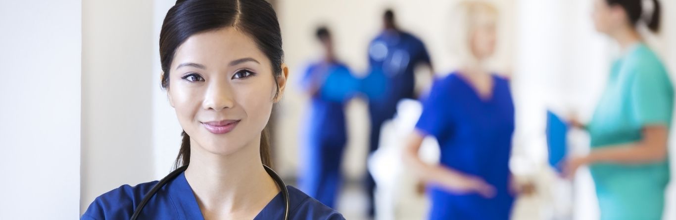 A lady nurse is standing in her uniform