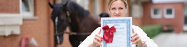 Female veterinarian holding certificate for advanced training in veterinary medicine