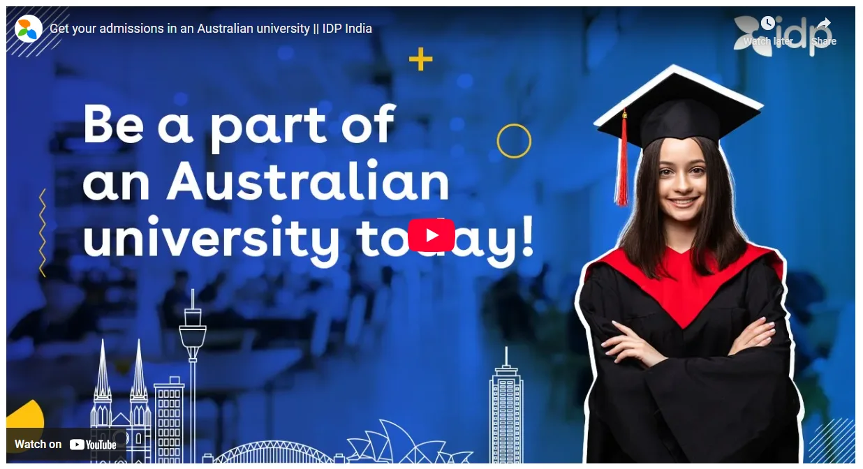 A smiling female graduate in cap and gown stands with crossed arms beside the text “Be a part of an Australian university today!” against a blue background with IDP and YouTube logos.