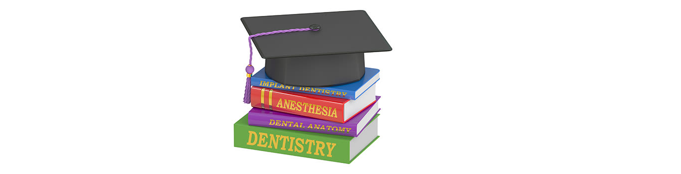 A graduation cap on top of a stack of dentistry text books