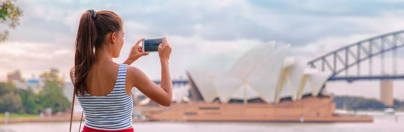 A lady is clicking pictures by using her mobile