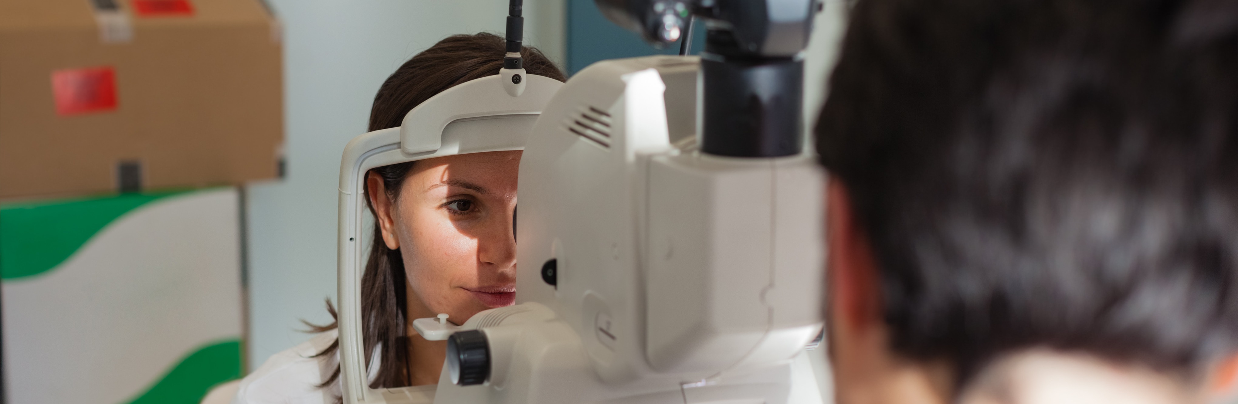 A young ophthalmologist using a non-mydriatic retinal camera on a young girl