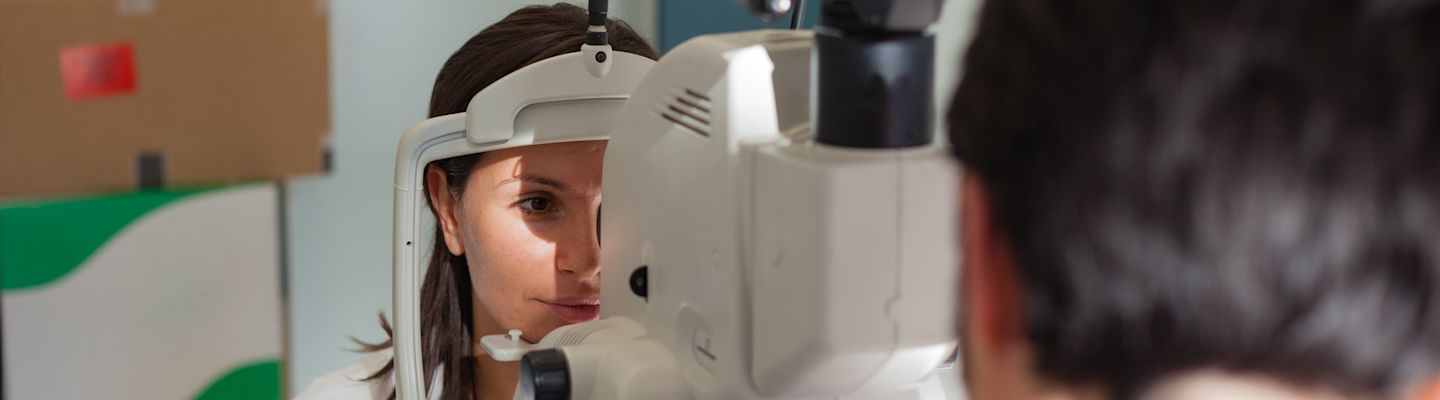 A young ophthalmologist using a non-mydriatic retinal camera on a young girl
